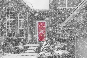 Winter storm and snow covering a home