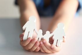 Life Insurance 101 person holding paper family cutouts in hands