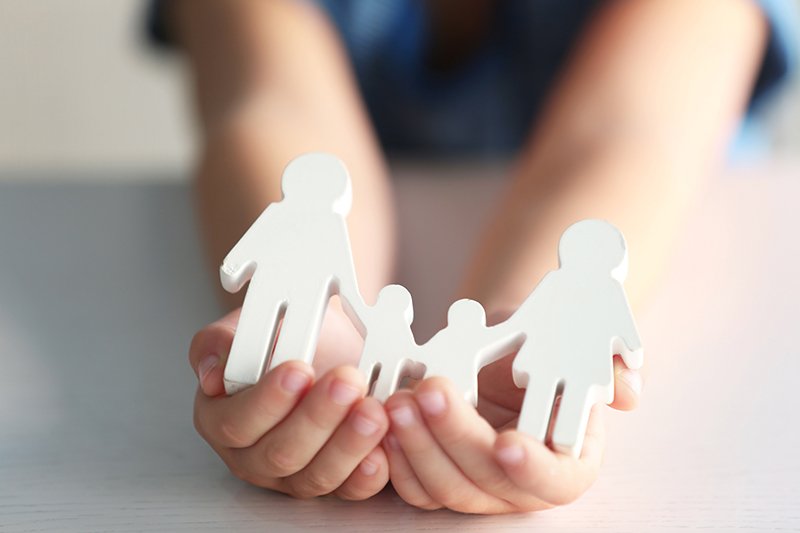 Life Insurance 101 person holding paper family cutouts in hands