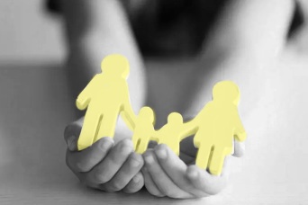 Hands holding a paper cut out of a family