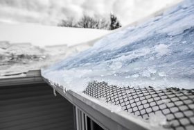 Snow and ice damaging the roof of a home